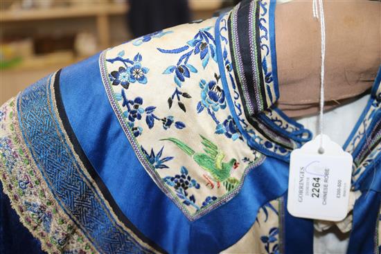 A Chinese silk embroidered robe c.1920s, embroidered with panels of birds and flowers on royal blue silk